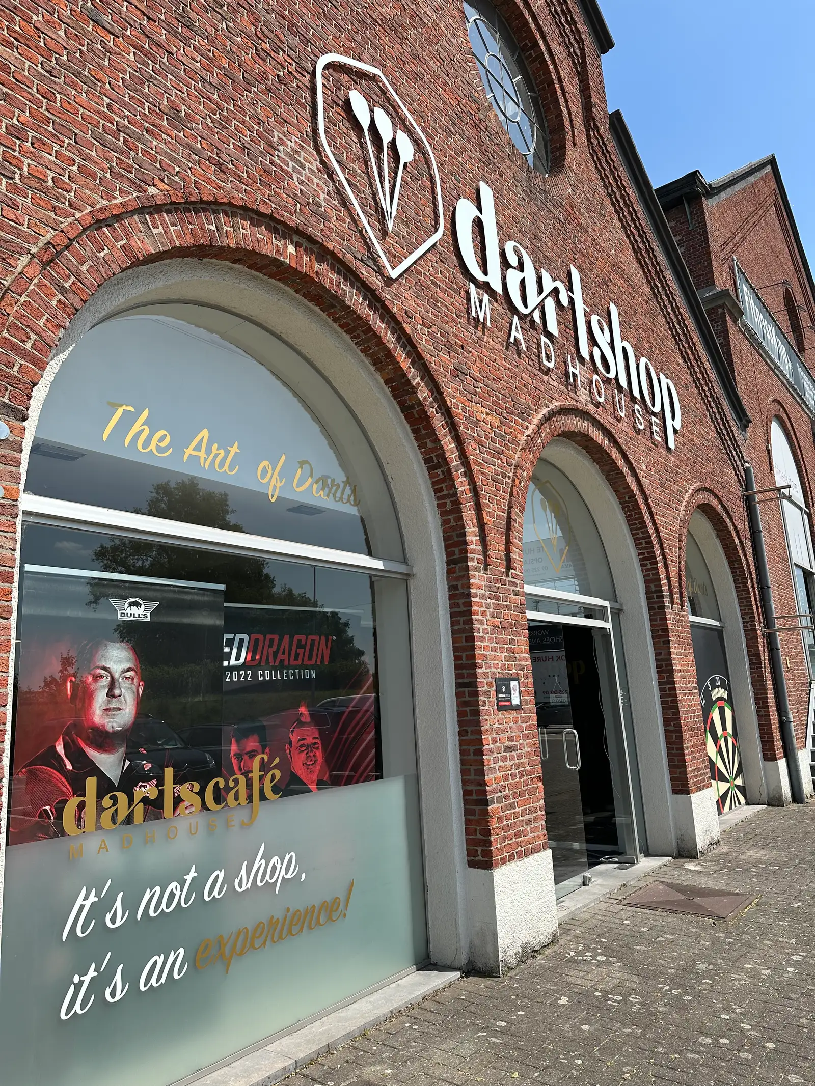 Gevel met gefreesde letters boven de boogvormige inkom van een winkelpand
